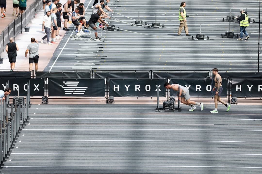 Athlete pushing a sled at a Hyrox event in Paris, the sport demand a Hyrox training protocol is built around