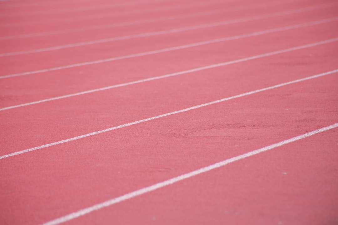 Close-up of a running-track surface and lane markings, evoking the sixteen-month arc of a Hyrox training protocol